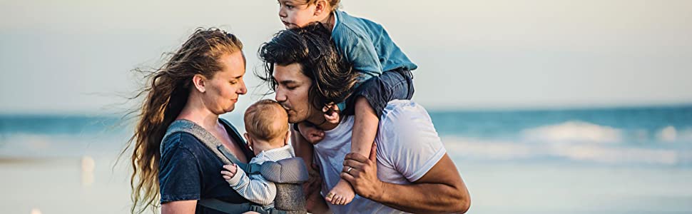 Mamma che tiene bambino in te pi?? me trasportatore con pap?? bacia la testa