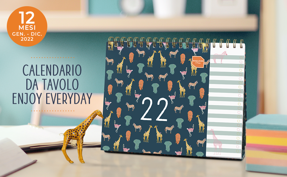 Il Calendario da Tavolo su una scrivania accanto a una giraffa giocattolo e una pila di post-it.